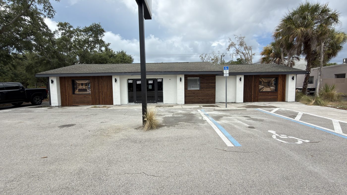 The same commercial building after renovation, with new siding, windows, and entry