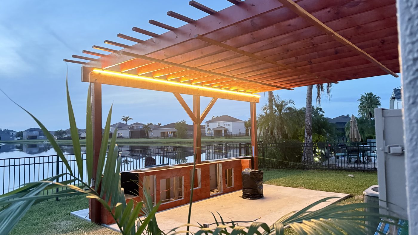 Finished pergola with warm integrated lighting overlooking the water